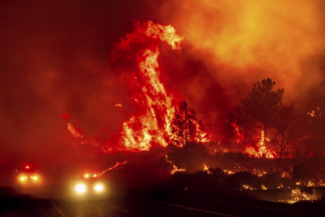 Gabe Huck (right), a member of a San Benito-Monterey Cal Fire crew, stands along state Highway 168 while fighting the Creek Fire on Sept. 6 in Shaver Lake (Fresno County). Marcio Jose Sanchez/Associated Press 2020