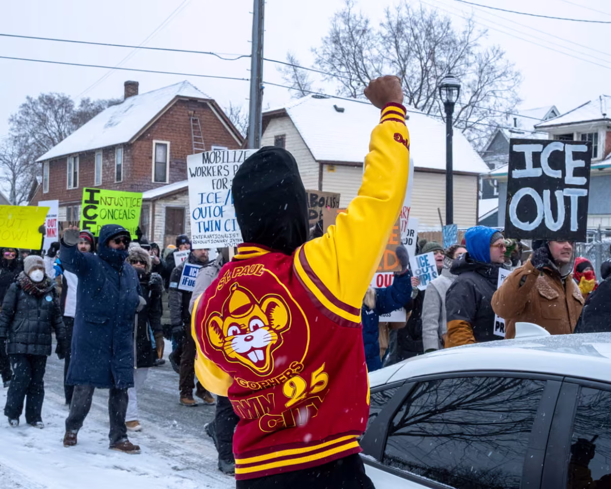 A spectator raises a fist to solidarity with the protestors from the postal workers union gathered commanding ICE to be out of Minnesota in Minneapolis, last Sunday. 